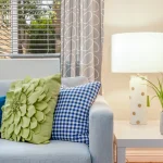 Blue sofa with colorful throw pillows and lamp