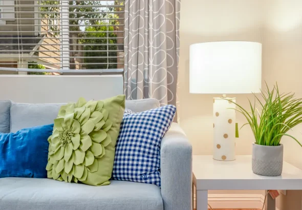 Blue sofa with colorful throw pillows and lamp