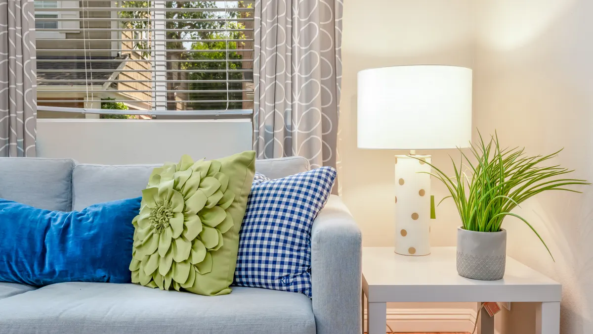 Blue sofa with colorful throw pillows and lamp